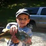 Young boy holding a fish from Beaver lake fishing